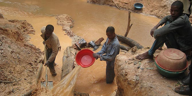 The dropping price of commodities such as coltan and tantalum being mined in the photo 