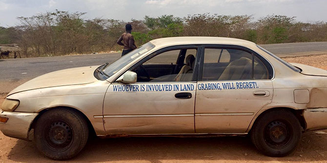 A car with a slogan, Whoever is involved in landgrabbing will regret