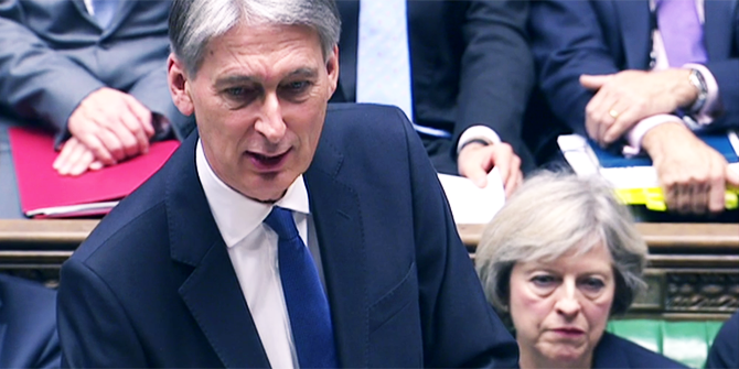 Philip Hammond delivers the 2016 Autumn Statement as Theresa May looks on from the benches.