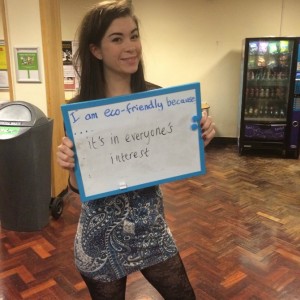 Student holding a whiteboard saying "I'm eco friendly because it's in everyone's interest"