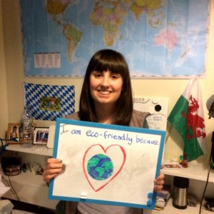 Student holding a whiteboard saying "I'm eco friendly because I love the world"